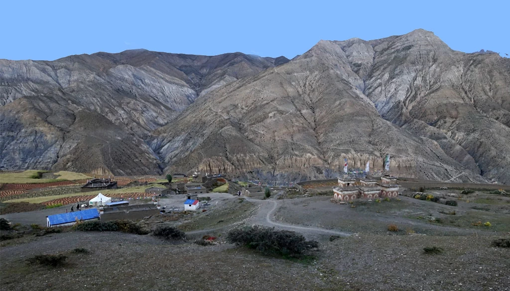 Beautiful farmland and chortens and desolate mountain peaks is pictured during the Upper Dolpo Trekking.