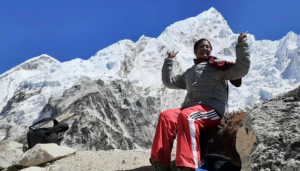A senior citizen taking pictures EnRoute to Everest base camp and beautiful mount Nuptse in the background.