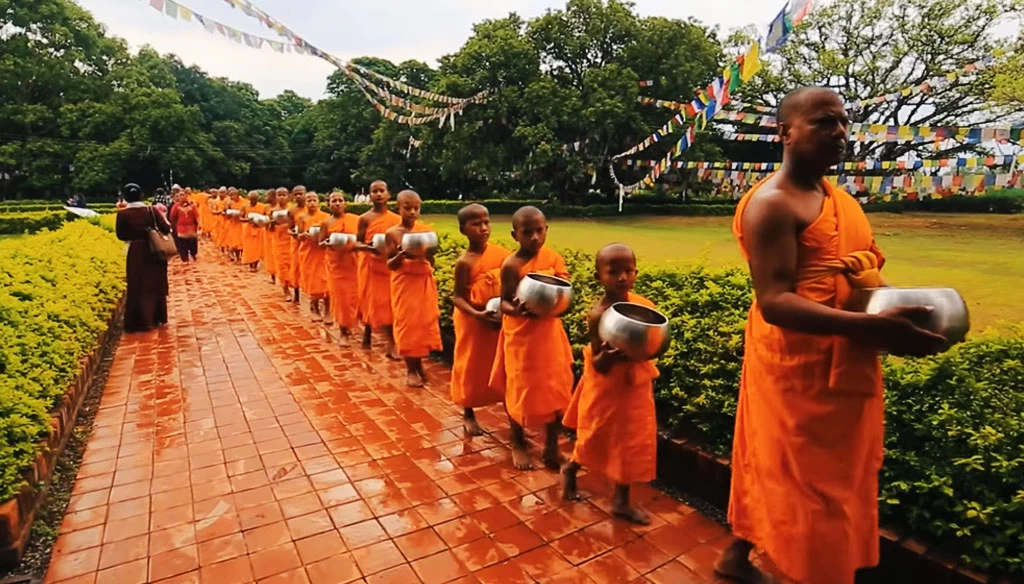 monks are going outside of the premises for asking alms in lumbini